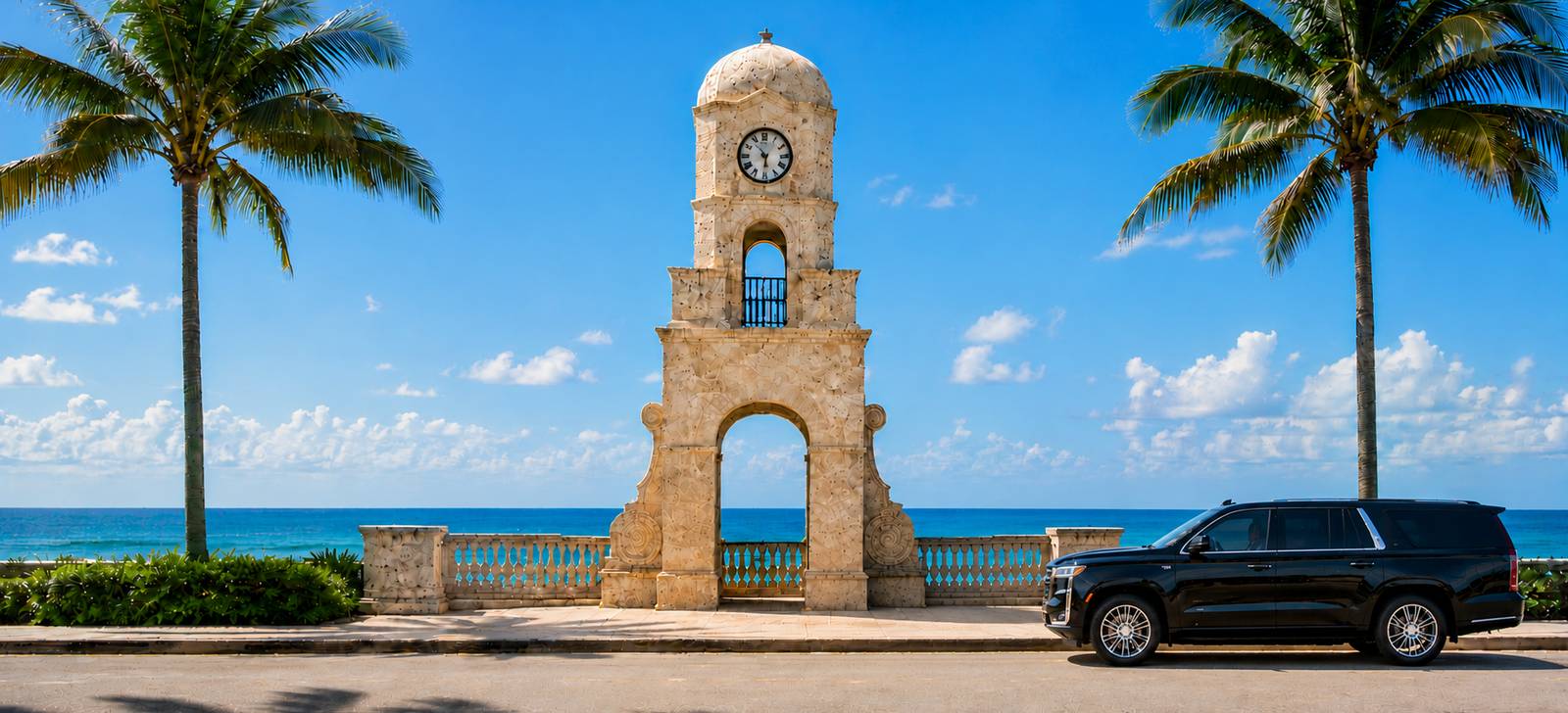 The Worth Avenue clock tower by the ocean in Palm Beach, framed by palm trees